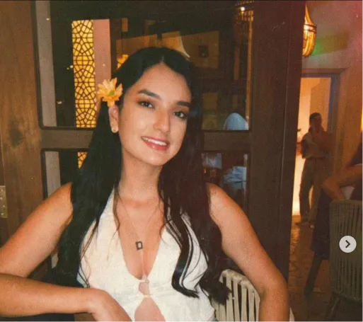 Ana María, fundadora de Ottoke, sonríe con una flor amarilla en el pelo.