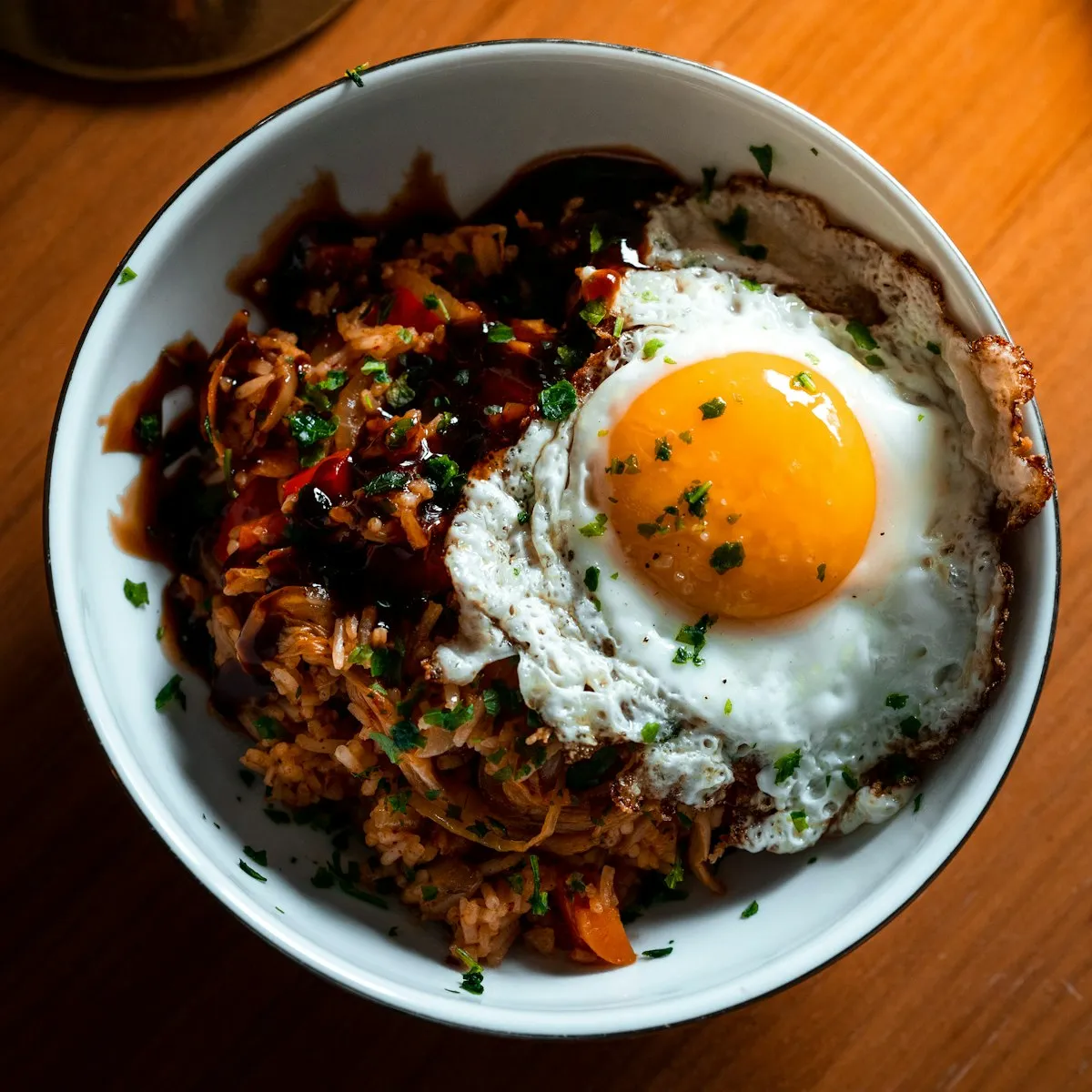 Arroz frito con un huevo frito encima en un bol blanco