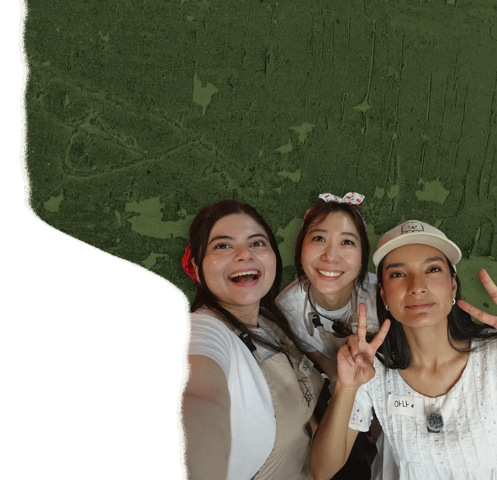 Tres mujeres sonríen en una selfie durante un taller de Ottoke; dos hacen el signo de la paz.